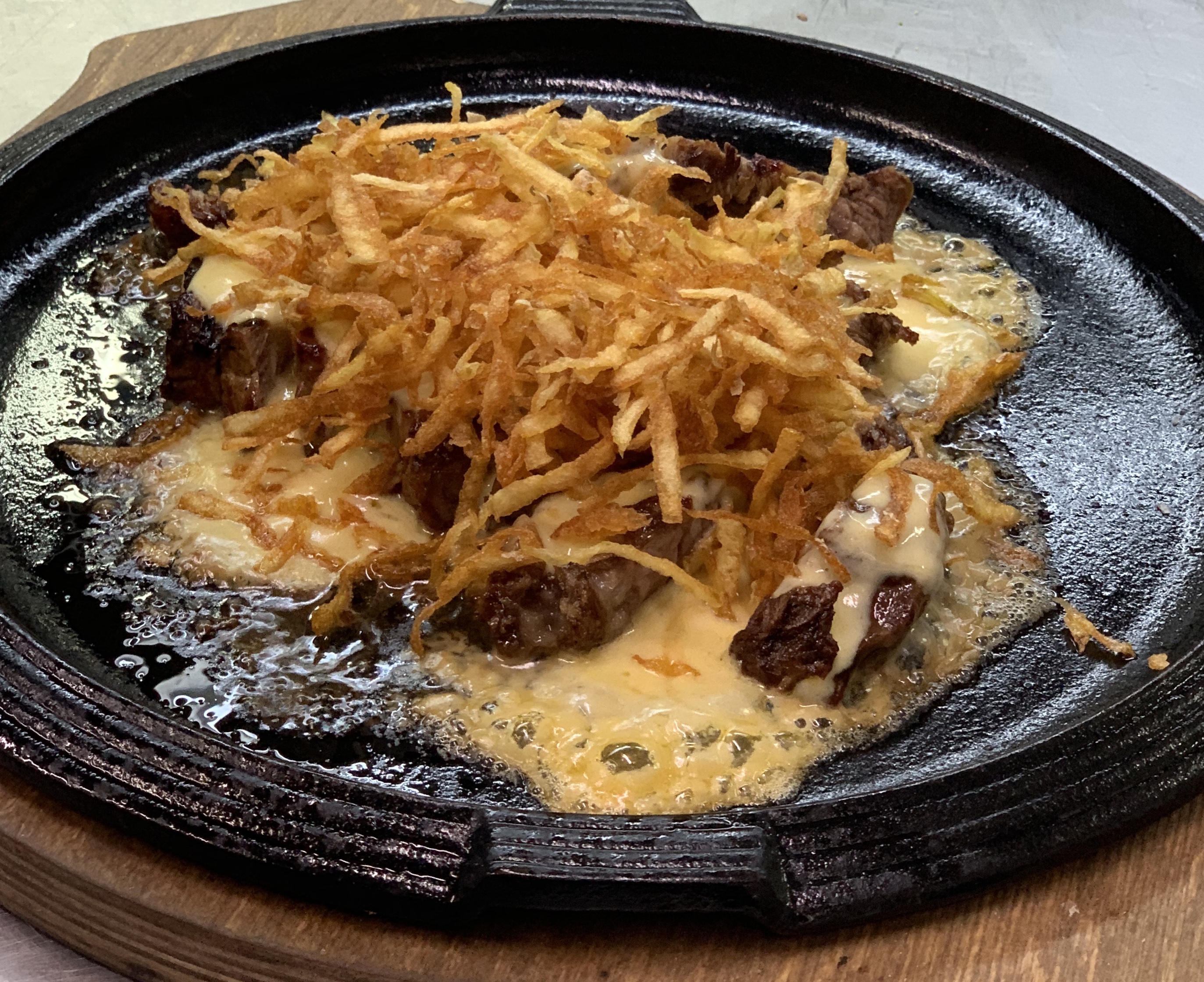 Tagliata di manzo con fonduta di formaggi e croccante di patate fresche